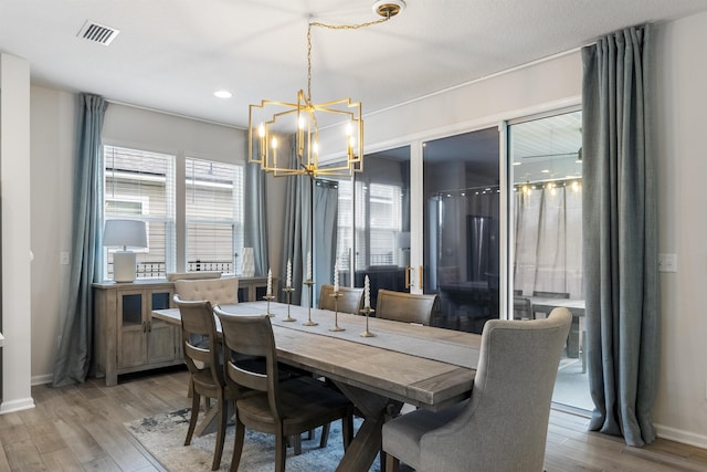 dining area featuring plenty of natural light, a chandelier, and light wood-type flooring