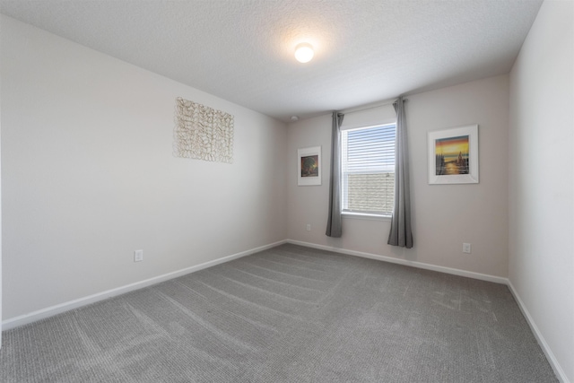 carpeted empty room with a textured ceiling