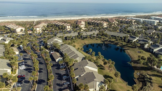 drone / aerial view with a beach view, a water view, and a residential view