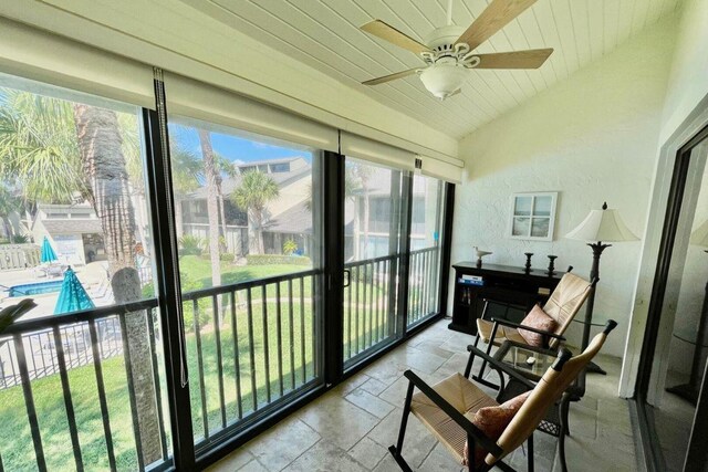 sunroom / solarium featuring lofted ceiling, wood ceiling, and a ceiling fan