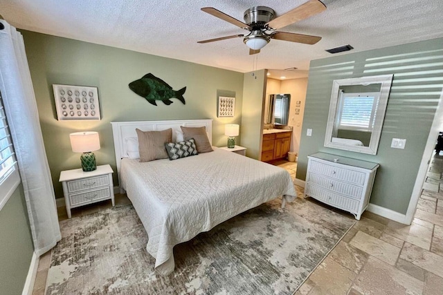 bedroom featuring baseboards, a textured ceiling, visible vents, and stone tile floors