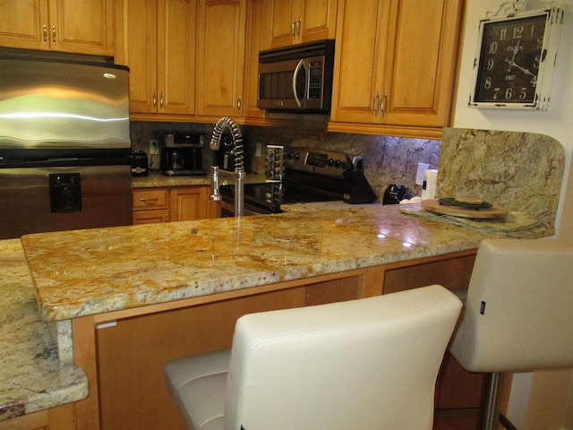 kitchen featuring appliances with stainless steel finishes, brown cabinetry, and tasteful backsplash