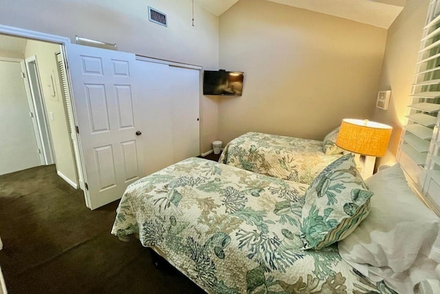 carpeted bedroom with visible vents and vaulted ceiling