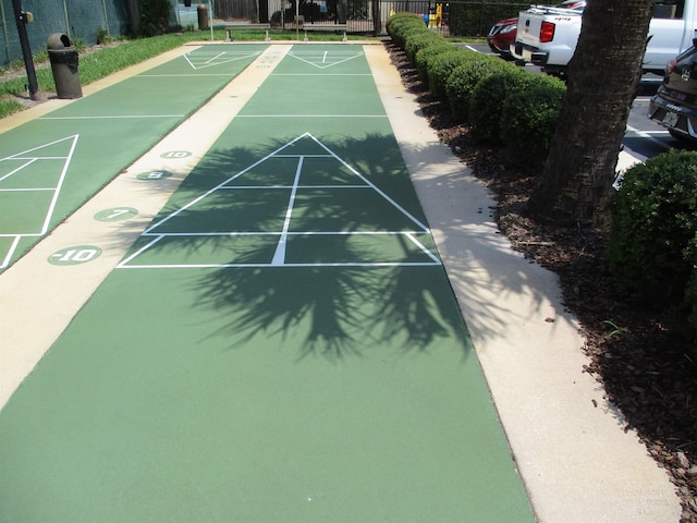 view of community featuring fence and shuffleboard