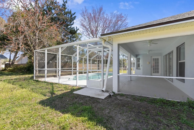 view of yard featuring glass enclosure, a patio, a fenced in pool, and a ceiling fan