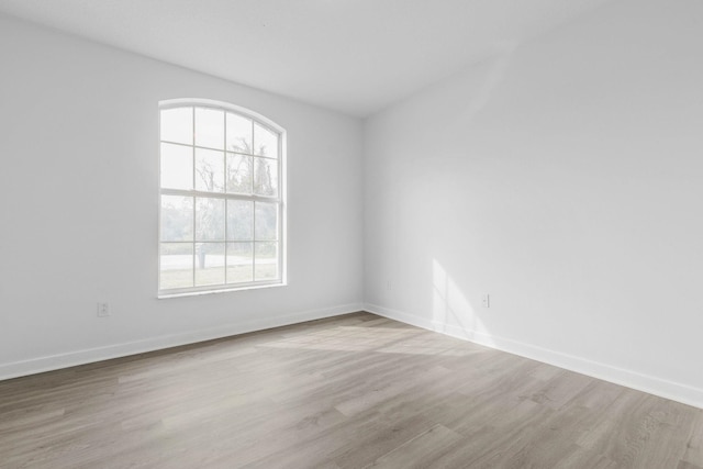 unfurnished room with baseboards and wood finished floors