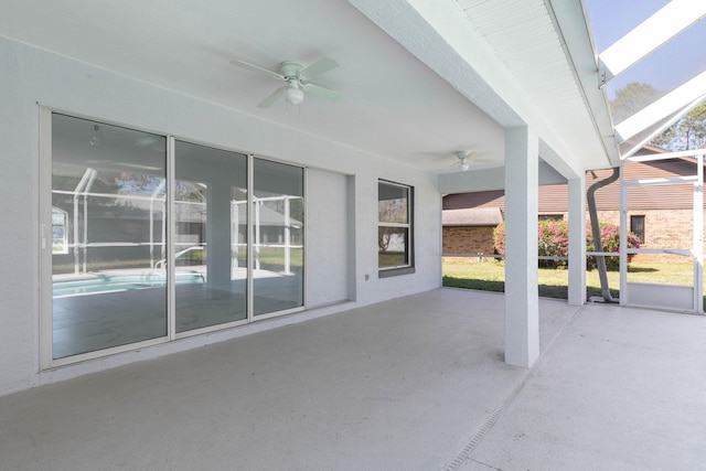 view of patio featuring glass enclosure and a ceiling fan