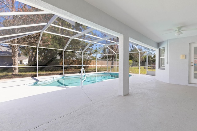 view of swimming pool with a patio area, glass enclosure, a ceiling fan, and fence