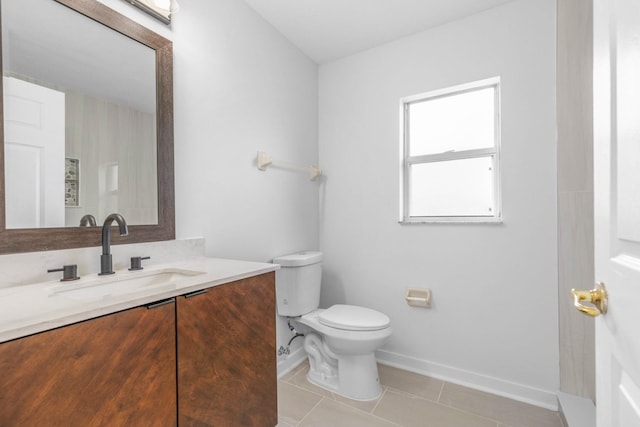 bathroom featuring baseboards, toilet, vanity, and tile patterned flooring