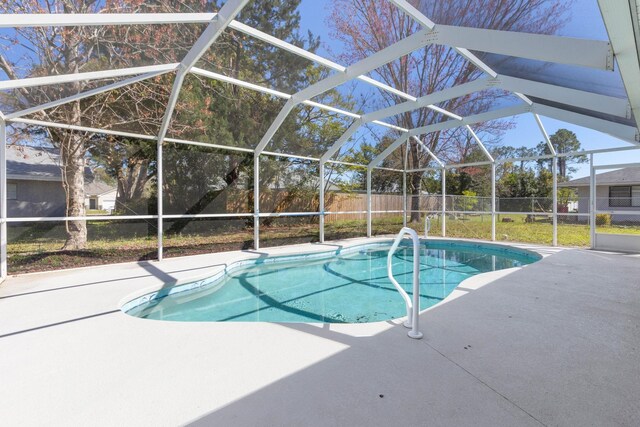 view of swimming pool with glass enclosure, a patio area, a fenced backyard, and a fenced in pool