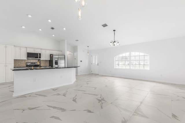 kitchen with visible vents, decorative backsplash, appliances with stainless steel finishes, dark countertops, and open floor plan