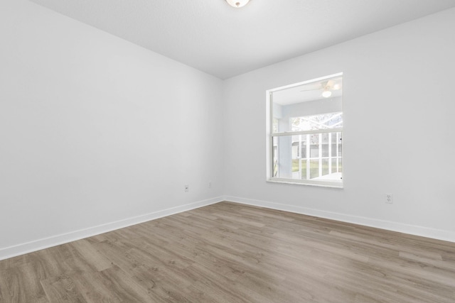 unfurnished room with baseboards and wood finished floors