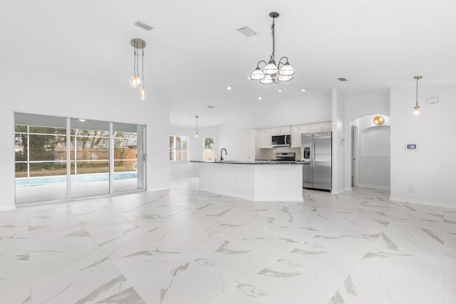 kitchen featuring high vaulted ceiling, a sink, stainless steel appliances, marble finish floor, and open floor plan