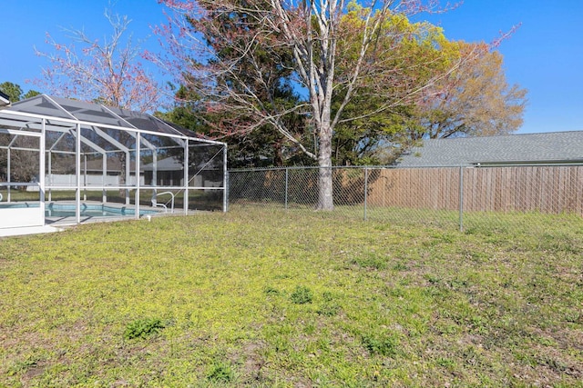 view of yard featuring a lanai, a fenced in pool, and a fenced backyard