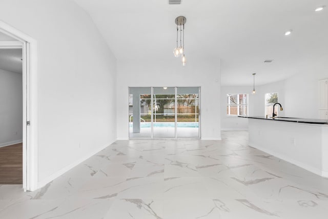 unfurnished living room with visible vents, baseboards, marble finish floor, and a sink