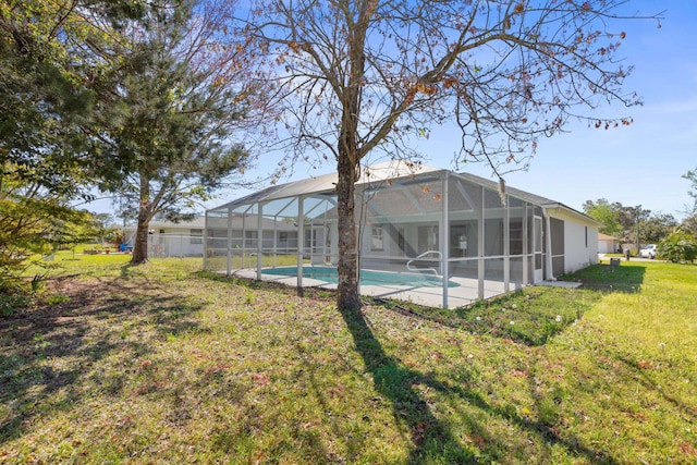 view of yard featuring a lanai, a patio area, and an outdoor pool