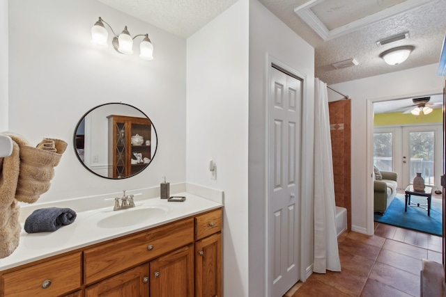 bathroom featuring tile patterned floors, shower / tub combo with curtain, vanity, and a textured ceiling