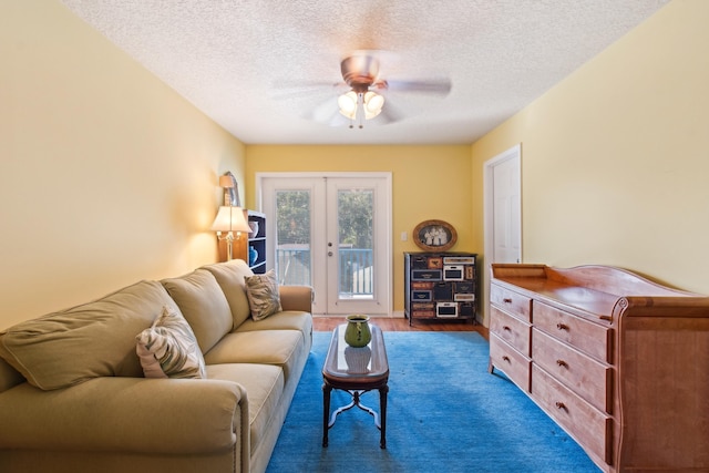 living room featuring a textured ceiling, wood-type flooring, french doors, and ceiling fan