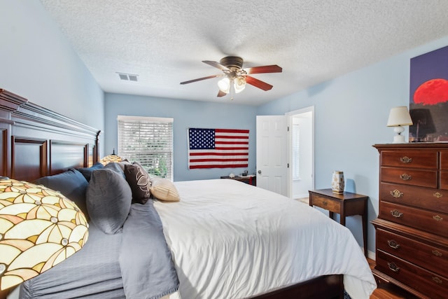 bedroom with ceiling fan and a textured ceiling