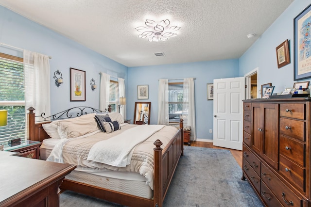 bedroom with a textured ceiling and light wood-type flooring