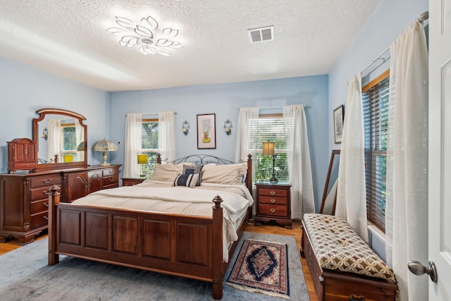 bedroom with hardwood / wood-style floors and a textured ceiling