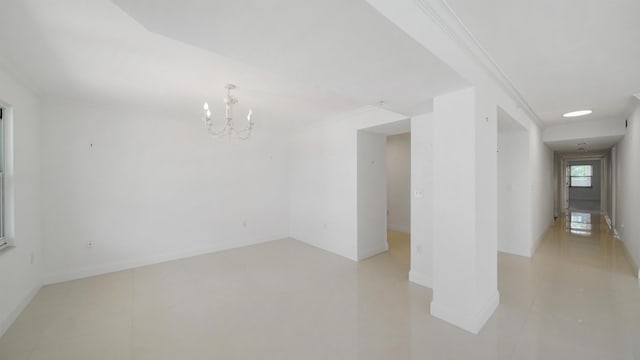 1 John Anderson Dr Unit 218, Ormond Beach, FL 32176 - empty room featuring a chandelier, ornamental molding, baseboards, and light tile patterned floors