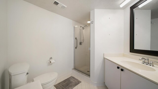 1 John Anderson Dr Unit 218, Ormond Beach, FL 32176 - bathroom featuring toilet, vanity, a shower stall, tile patterned floors, and baseboards