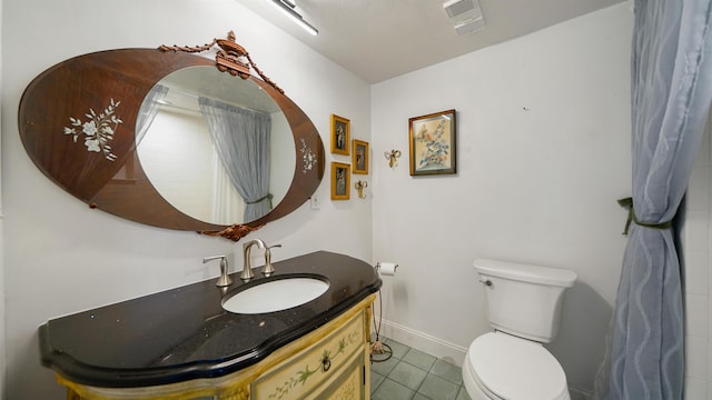 1 John Anderson Dr Unit 218, Ormond Beach, FL 32176 - bathroom featuring toilet, vanity, tile patterned flooring, and baseboards