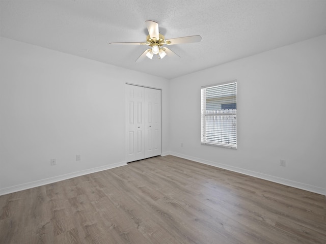 empty room featuring light hardwood / wood-style floors, a textured ceiling, and ceiling fan