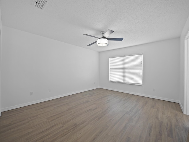 unfurnished room with a textured ceiling, ceiling fan, and dark hardwood / wood-style flooring