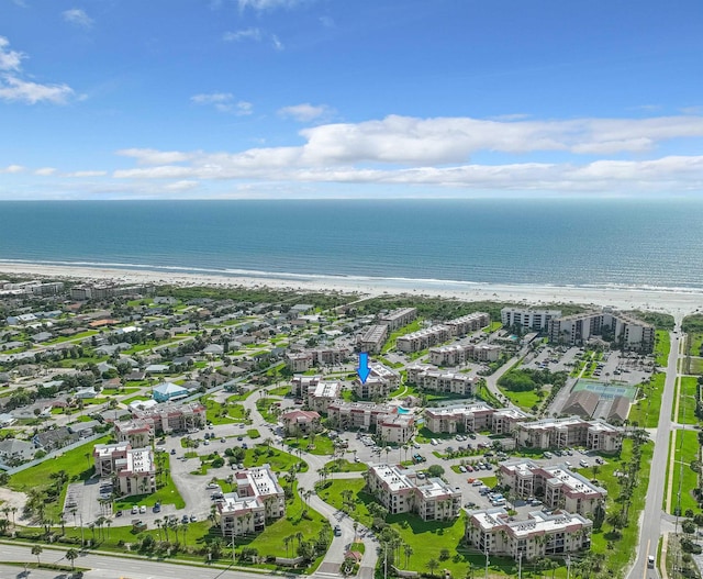 birds eye view of property with a water view and a beach view