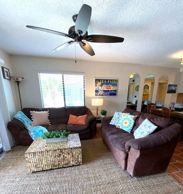 living room featuring a textured ceiling, tile patterned floors, and ceiling fan