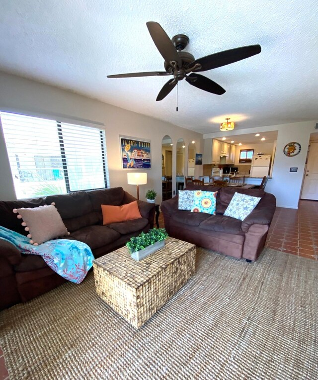 tiled living room with a textured ceiling and ceiling fan