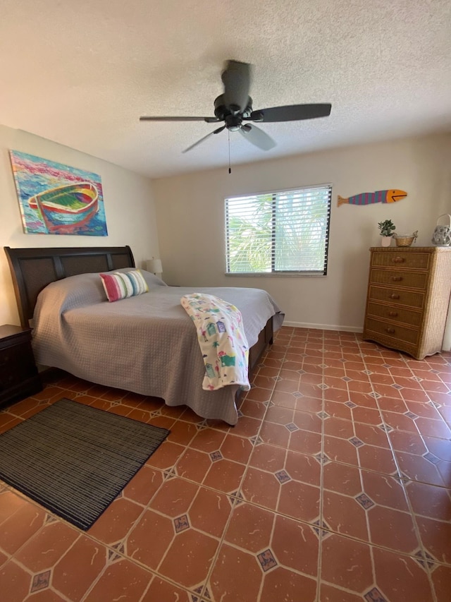 bedroom featuring tile patterned flooring, ceiling fan, and a textured ceiling