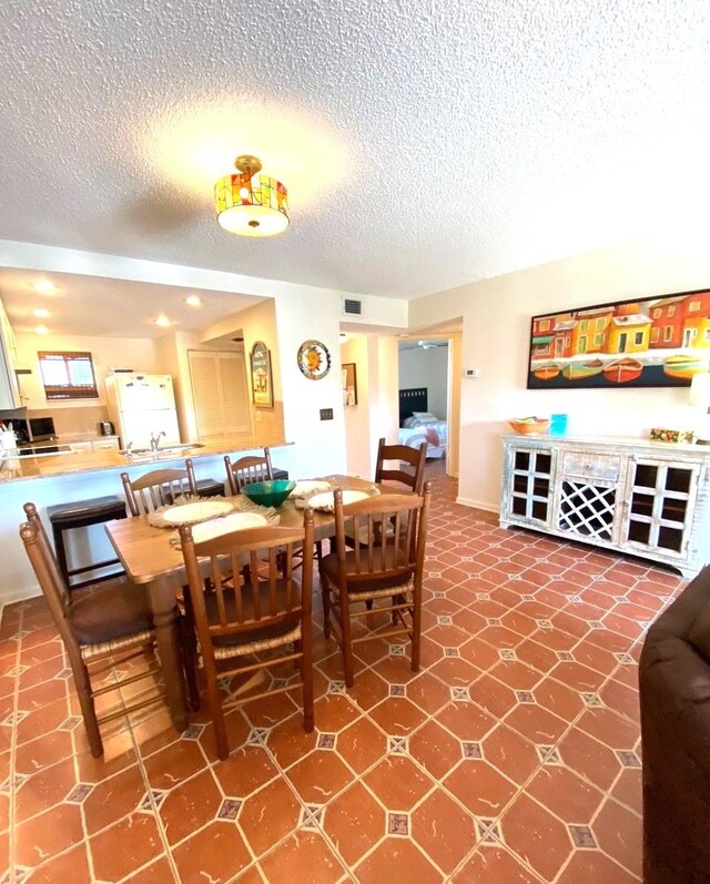 dining space featuring a textured ceiling