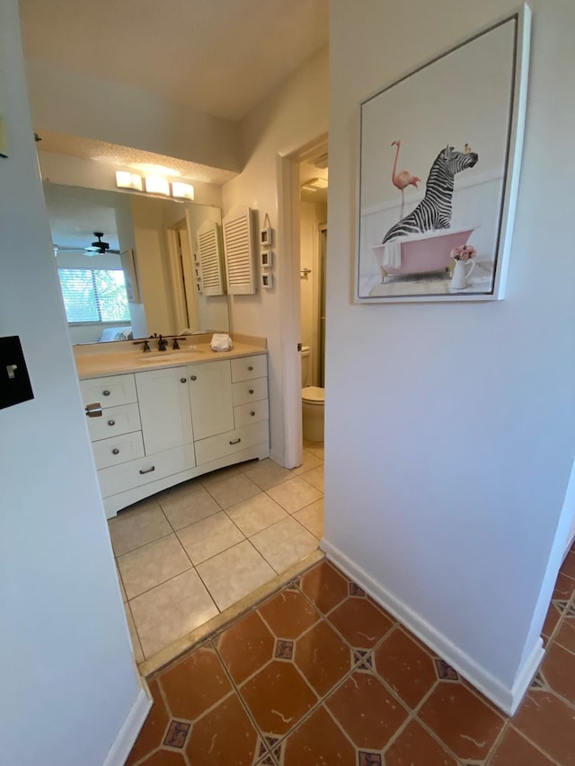 bathroom featuring tile patterned floors, vanity, ceiling fan, and toilet