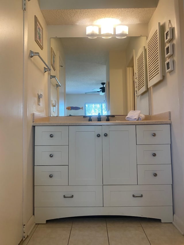 bathroom with tile patterned flooring, vanity, a textured ceiling, and ceiling fan