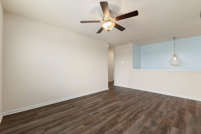 unfurnished room featuring dark wood-style floors, ceiling fan, and baseboards