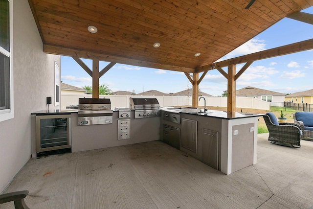 view of patio / terrace featuring a sink, grilling area, an outdoor kitchen, and a fenced backyard