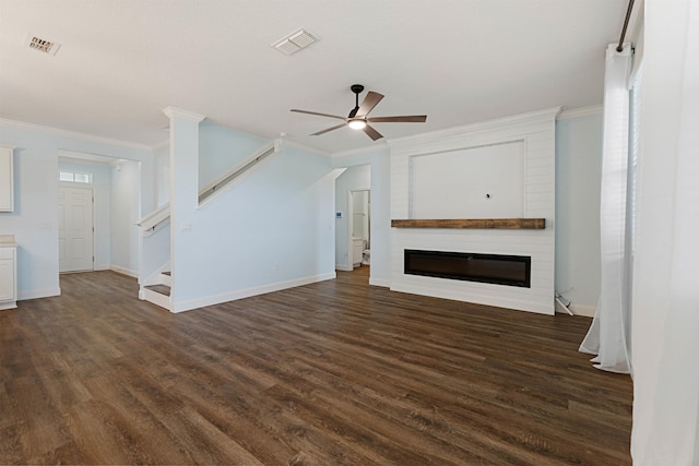 unfurnished living room featuring stairs, a fireplace, visible vents, and dark wood finished floors