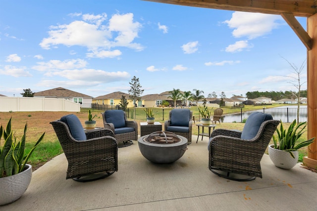 view of patio / terrace featuring a water view, a fenced backyard, a residential view, and a fire pit