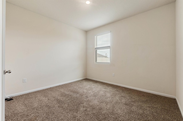 unfurnished room with carpet and baseboards