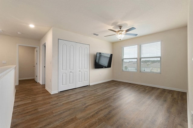 unfurnished bedroom with a ceiling fan, visible vents, baseboards, a closet, and dark wood-style floors