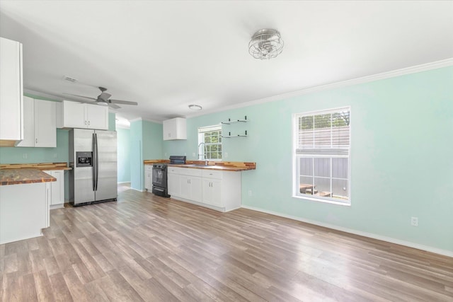 10160 Ebert Ave, Hastings, FL 32145 - kitchen featuring stainless steel refrigerator with ice dispenser, butcher block counters, gas stove, ornamental molding, and light wood-type flooring