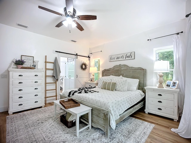 8975 Reid Packing House Rd, Hastings, FL 32145 - bedroom with a barn door, wood finished floors, and ceiling fan