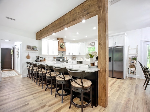 8975 Reid Packing House Rd, Hastings, FL 32145 - kitchen with stainless steel appliances, light wood-type flooring, a kitchen bar, a peninsula, and beam ceiling