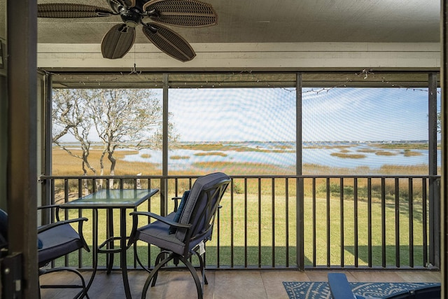 sunroom / solarium featuring a water view, ceiling fan, and plenty of natural light