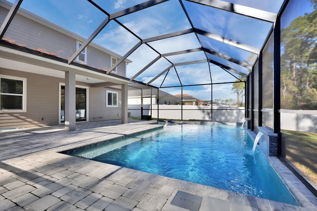 view of swimming pool with pool water feature, a patio, and glass enclosure