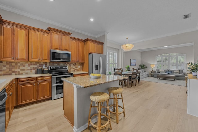 kitchen featuring pendant lighting, backsplash, a chandelier, a kitchen breakfast bar, and stainless steel appliances