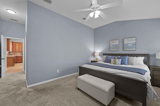 carpeted bedroom with a textured ceiling, vaulted ceiling, and ceiling fan